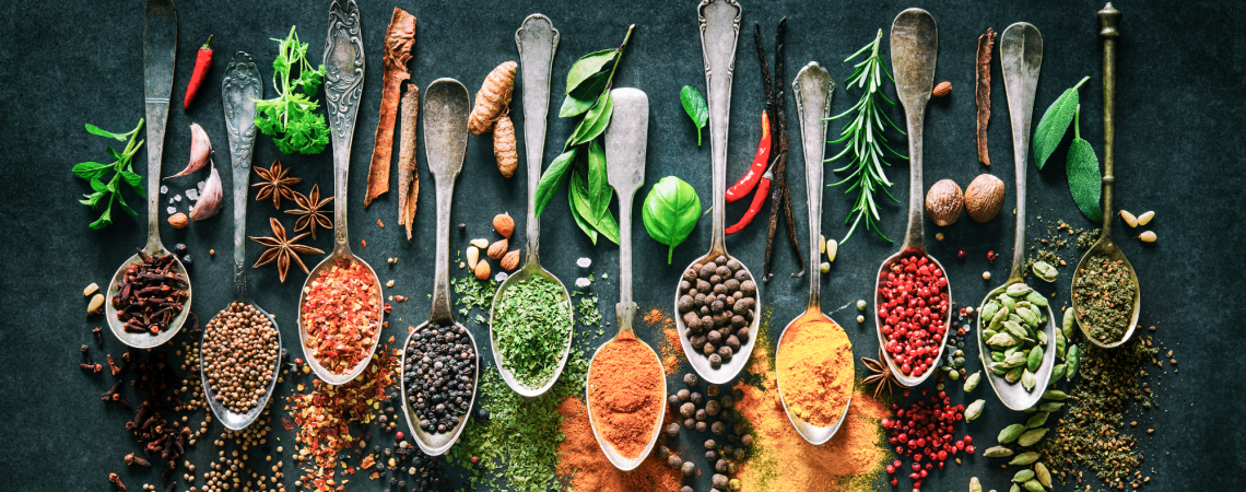 Verschiedene Gewürze auf dekorativen Löffeln, abwechslungsreich und farbenprächtig arrangiert.