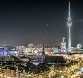 Nächtliche Berliner Skyline mit Fernsehturm und beleuchteten Gebäuden.