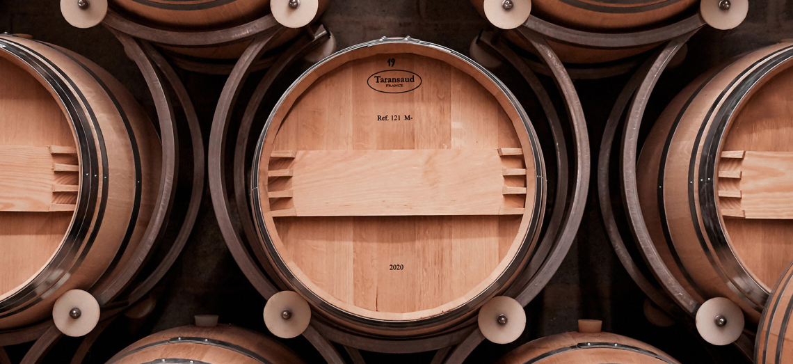 Holzfässer in einem Weinkeller ordentlich in Reihen gestapelt.