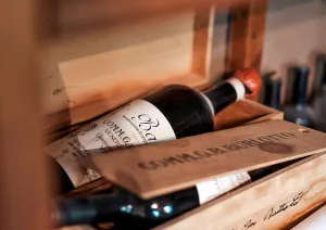 Weinflasche in einer hölzernen Kiste mit rustikalem Design.