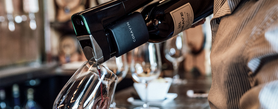 Wein wird mit einem schwarzen Gerät in ein Glas eingefüllt.