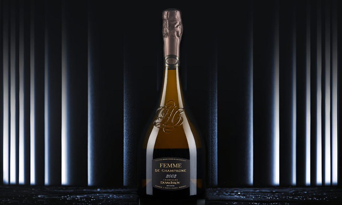 Elegante Champagnerflasche mit goldener Gravur vor monochromem, stilvollem Hintergrund.