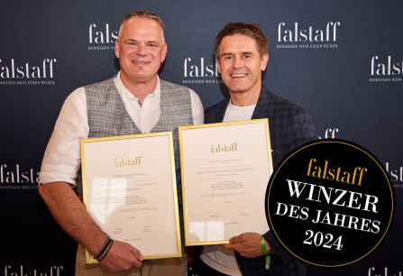 Zwei Männer halten Auszeichnungen vor einem Falstaff-Hintergrund.