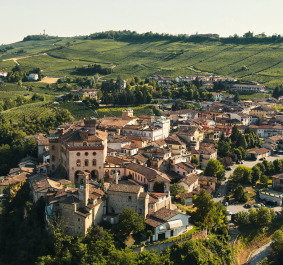 Malerische italienische Kleinstadt umgeben von sanften grünen Hügeln und Weinbergen.