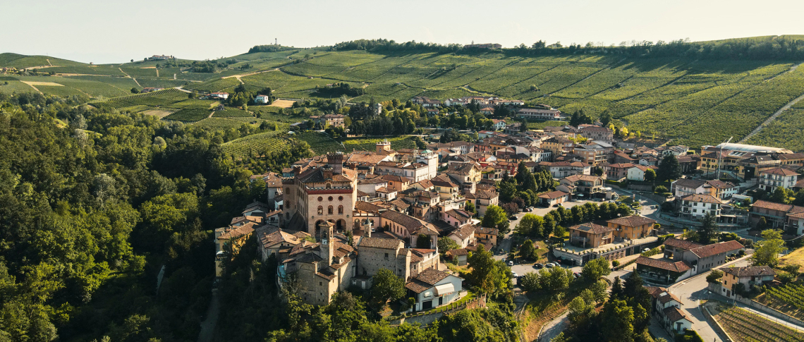 Malerische italienische Kleinstadt umgeben von sanften grünen Hügeln und Weinbergen.