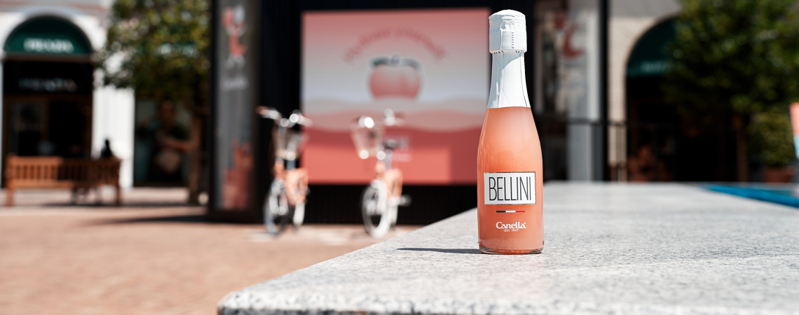 Rosa Bellini-Flasche im Freien auf einem steinernen Tisch, verschwommener Hintergrund.
