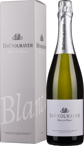 Flasche mit grünem Glas und silbernem Folienverschluss, neben einer beigen Box mit schwarzer und silberner Schrift und einem eleganten Design.