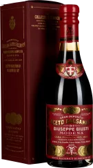 Eine elegante, dunkle Flasche Balsamico-Essig mit einem kunstvoll gestalteten roten Etikett und goldenen Verzierungen. Daneben steht eine passende, edle rote Verpackungsbox mit goldfarbenem Text.
