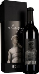 Dunkle Weinflasche neben einer eleganten schwarzen Geschenkbox, beide verziert mit der Abbildung einer klassischen Statue in Grautönen.