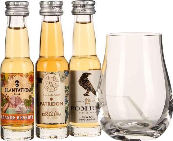 Drei Mini-Rumflaschen neben einem klaren, eleganten Glas.