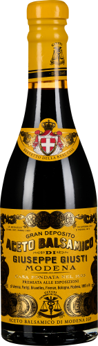 Gelbe Balsamico-Flasche mit traditionellen Verzierungen und schwarzer Schrift.