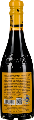 Dunkle Balsamico-Flasche mit gelbem Etikett und Siegel, silberner Schriftzug.