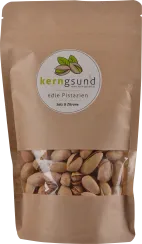 Braune Kraftpapier-Verpackung mit Sichtfenster, das geöffnete Pistazien zeigt. Einfache, natürliche Optik mit grünem Logo und minimalistischem Design.