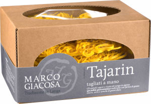 Braune Kartonverpackung mit ovalem Fenster, das goldgelbe, handgemachte Tagliatelle-Nudeln zeigt. Dezente graue Banderole mit kontrastierendem Text.