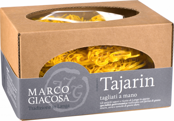 Braune Kartonverpackung mit ovalem Fenster, das goldgelbe, handgemachte Tagliatelle-Nudeln zeigt. Dezente graue Banderole mit kontrastierendem Text.