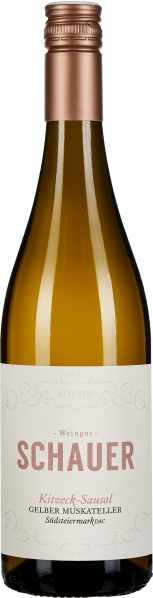 Die Weinflasche zeigt einen klaren, eleganten Look mit einer dezenten Papieretikette in Cremefarbe und bronzefarbenem Aufdruck. Die Flasche hat einen metallisch schimmernden Schraubverschluss in bronzefarbenem Ton und enthält einen hellen, goldgelben Wein