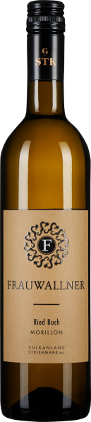 Die Weinflasche zeigt sich in einem eleganten, klaren Glas mit goldenem Inhalt. Das Etikett ist in einem sanften, erdigen Ton gehalten, verziert mit einem filigranen, dunklen Ornament und einer mittig platzierten Schrift. Der Verschluss ist schwarz mit go