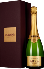 Eine elegante Champagnerflasche mit goldener Folie über dem Korken steht neben einer dunkelroten Geschenkbox. Die Etiketten auf Flasche und Box sind in einem klassischen Design gehalten.