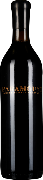 Schlanke, hohe Weinflasche mit tiefdunklem Glas, einfachem schwarzem Halsabschluss und einer eleganten, goldenen Beschriftung.