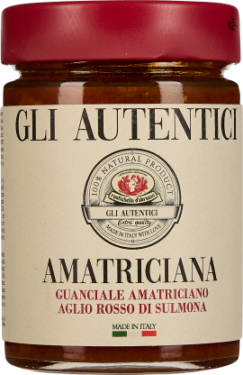 Das Bild zeigt ein Glas mit rotem Deckel, gefüllt mit einer roten Sauce. Das Etikett ist cremefarben mit schwarzer und roter Schrift. Ein stilisiertes Emblem in der Mitte enthält ein rotes Logo. Darunter verläuft ein grüner, weißer und roter Streifen, sim