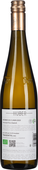 Schlanke Flasche mit goldenem Schraubverschluss, klare grüne Weinflüssigkeit sichtbar.