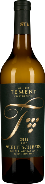Die Weinflasche hat ein elegantes Etikett in dunklem Grün mit goldener Schrift und Verzierung. Der Flaschenkörper ist aus braunem Glas, was dem Wein eine edle Erscheinung verleiht. Der Verschluss ist schwarz mit goldener Schrift.