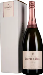 Flasche Rosé-Champagner mit glänzend rosa Folienverschluss vor weißer Geschenkbox.