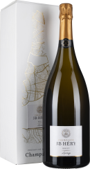 Große, grüne Champagnerflasche mit goldener Folie am Hals, daneben eine elegante, weiße Box mit goldenen Abstraktlinien.