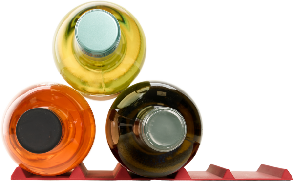 Drei bunte Glasflaschen auf rotem Flaschenhalter, von oben betrachtet.
