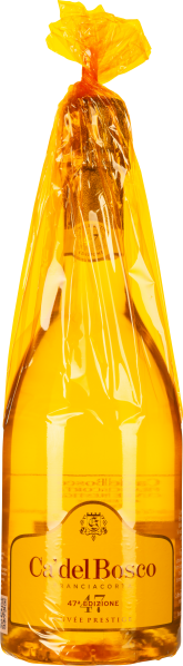 In gelber Folie verpackte Weinflasche mit goldener Flüssigkeit.