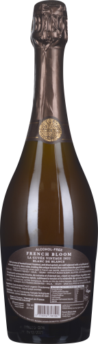 Braune Sektflasche mit goldener Verzierung und detailliertem Etikett auf dunklem Papier.