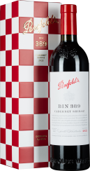 Weinflasche vor roter Schachbrett-Schachtel mit rotem Verschluss und elegantem Etikett.