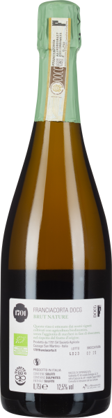 Grüne Sektflasche mit dunklem Glas und grünem Verschluss, Etikett mit weißem Hintergrund.