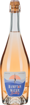 Flasche mit blassroséfarbenem Schaumwein und verkorktem Verschluss.