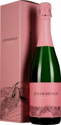 Flasche eines Rosé-Schaumweins vor einer passenden rosa Geschenkverpackung mit gezeichneter Landschaft. Die Flasche hat ein elegantes, minimalistisches Etikett in Rosa mit schwarzer Schrift. Der Flaschenverschluss ist ebenfalls in Rosa gehalten.