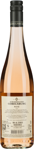 Durchsichtige Roséweinflasche mit schwarzem Verschluss und cremefarbenem Etikett.