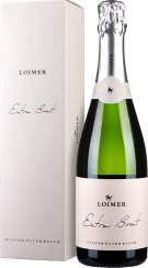 Eine Sektflasche mit grünem Glas, silberner Folienkapsel und einem cremefarbenen Etikett. Daneben steht eine farblich passende Box.