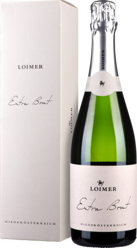 Eine Sektflasche mit grünem Glas, silberner Folienkapsel und einem cremefarbenen Etikett. Daneben steht eine farblich passende Box.