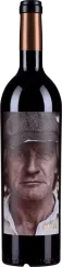 Dunkle Weinflasche mit einem auffälligen Etikett, das das Porträt eines älteren Mannes mit Schiebermütze zeigt. Kupferfarbener Flaschenverschluss, schlichtes Design.
