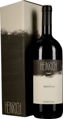 Eine dunkle Weinflasche mit schlichtem, eleganten Etikett, daneben eine passende Verpackung in erdigen Tönen mit künstlerischem Design.