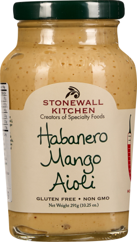 Glas mit helloranger Sauce mit leicht körniger Textur, dunkelgrüner Deckel, dezentes Etikett mit schwarzer Schrift.