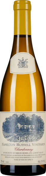 Flasche eines Weißweins mit gelber Flüssigkeit, kleinem Wappen oben und detaillierter Illustration einer Landschaft auf dem Etikett, das in Blau und Weiß gehalten ist.