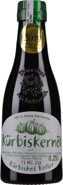 Flasche mit grünem Etikett und goldenem Siegel, das Kürbiskernöl enthält. Die Flasche ist dunkel und besitzt eine Prägung; der Verschluss hat einen grünen Streifen. Das Etikett zeigt grafische Kürbisse und ist textreich gestaltet.