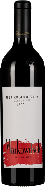 Die Weinflasche zeigt ein elegantes Design mit einem klaren Glas, das eine tiefrote Flüssigkeit enthält. Das Etikett ist überwiegend weiß mit einem auffälligen roten Akzent und stilvoller schwarzer Schrift. Die Flasche hat einen dunklen, glänzenden Schrau