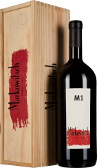 Eine elegante Weinflasche mit einem minimalistischen weißen Etikett und der Beschriftung "M1" steht neben einer dekorativen Holzkiste mit rotem Design.