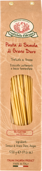 Packung italienischer Bucatini aus Hartweizengrieß in hellem Kraftpapier mit ovalem Sichtfenster, durch das die goldgelben Nudeln sichtbar sind. Oberhalb des Fensters befindet sich ein traditionelles Logo mit rotem und grünem Text.