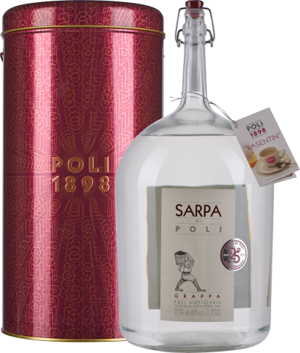 Große, klare Glasflasche mit Metallverschluss, etikettiert mit elegantem Design. Daneben steht eine metallische, rot-gold verzierte Geschenkdose.