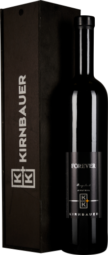 Die Flasche ist schlank und hoch mit einem glänzenden, schwarzen Etikett, auf dem dezente weiße und goldene Schriftzüge zu sehen sind. Die Weinkiste im Hintergrund ist ebenfalls schwarz und besitzt ein schlichtes Design mit weißem Logo.