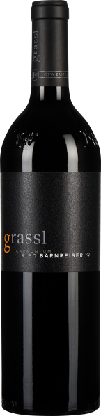 Flasche dunklen Weins mit elegantem, mattschwarzem Etikett und kontrastierender orangefarbener Schrift, vor schwarzem Hintergrund.