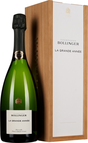 Grüne Sektflasche mit schwarzem Verschluss, etikettiert, daneben eine elegante, hölzerne Geschenkbox mit weißem Deckel.